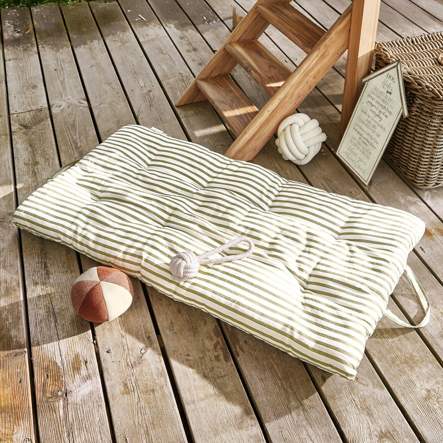 Matras voor huisdieren Selinah Gewatteerd kussen met groene strepen op houten terras met hondenspeelgoed