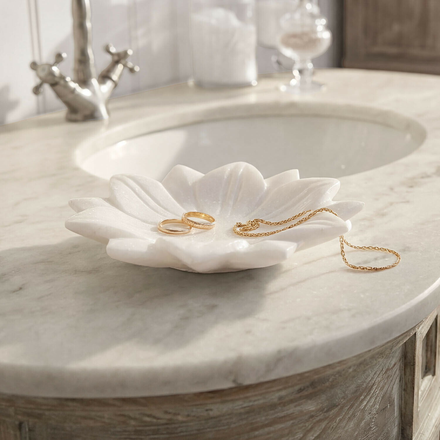 Schaal Dolcin Witte marmeren schaal in bloemvorm voor sieraden op een marmeren wastafel in de badkamer