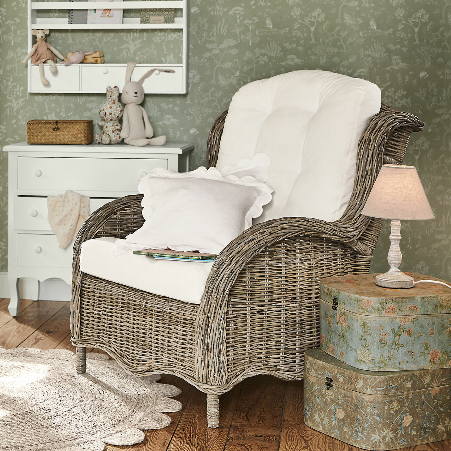 Rotan fauteuil met wit kussen in gezellige kamer met lamp en decoratieve kast