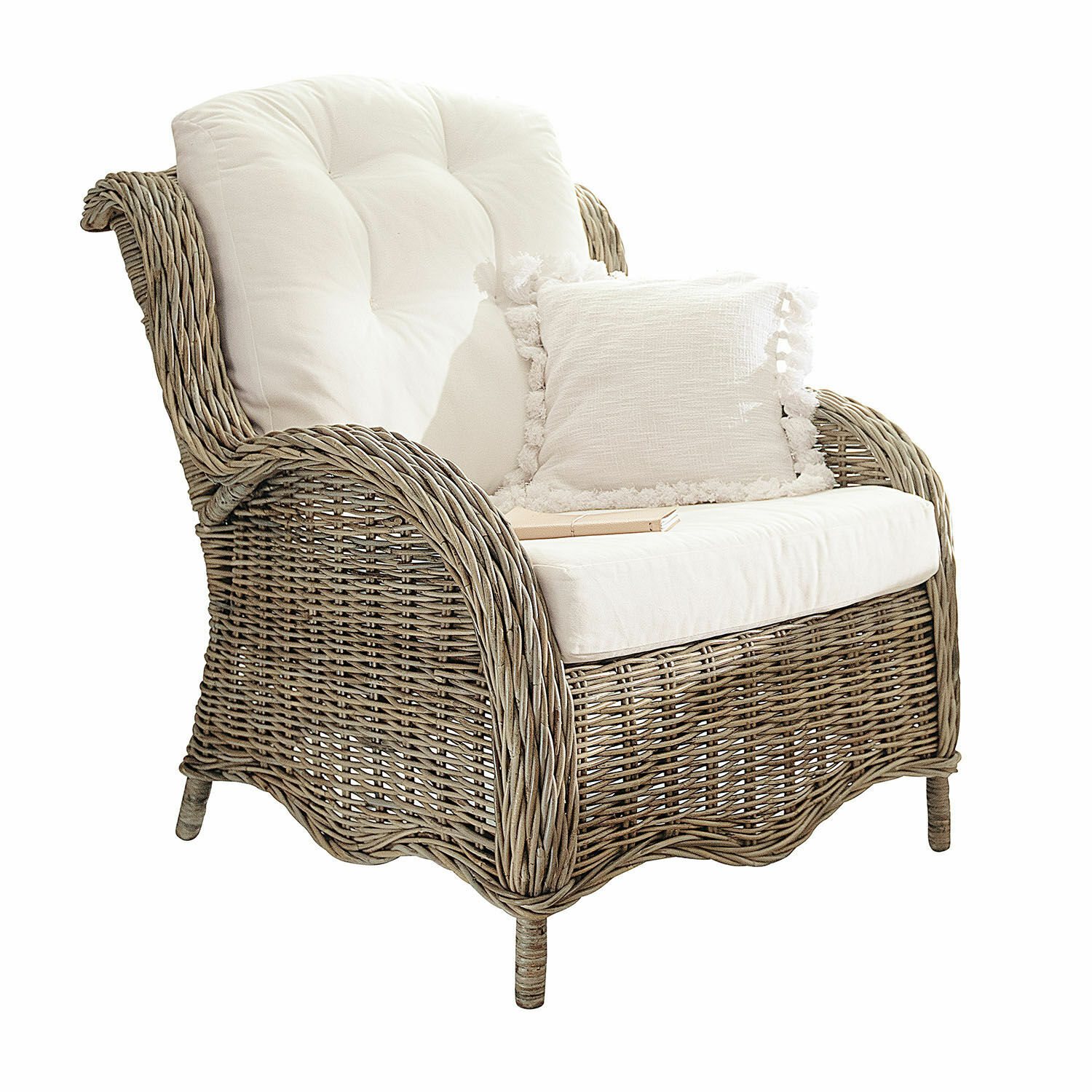 Rotan fauteuil in natuurlijke kleur met wit zacht kussen en decoratief kussen met franjes