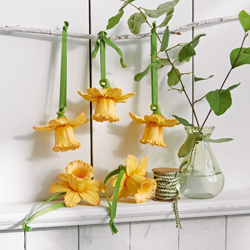 Gele stoffen bloemen met groene linten om op te hangen, natuurlijke decoratie voor binnen.