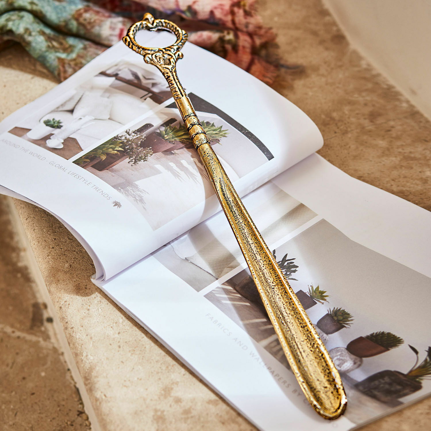 Schoenlepel Lucas Gouden metalen schoenlepel met decoratieve handgreep op een open interieurmagazine