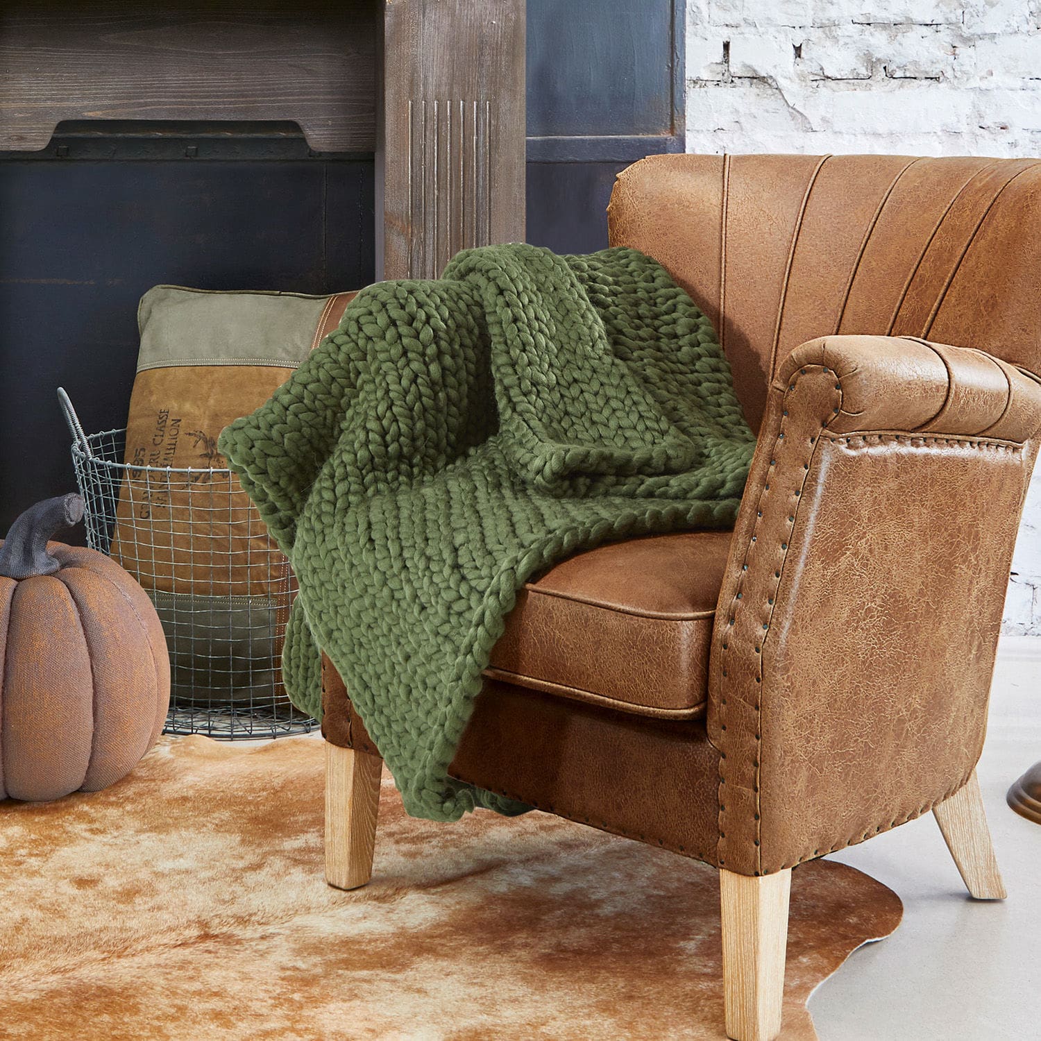Plaid Reidous Bruine kunstleren fauteuil met dikke groene deken op lichte vintage vloerkleed