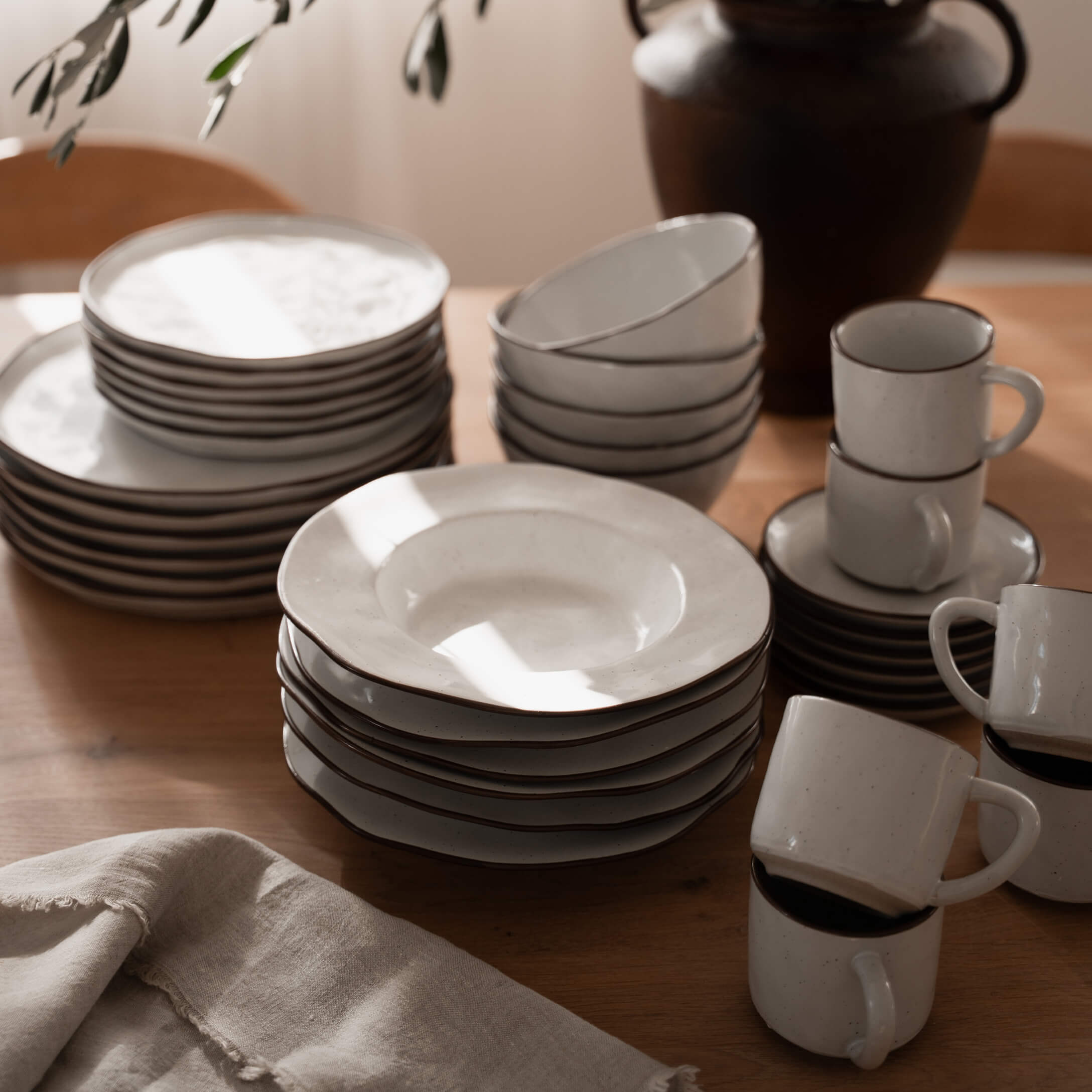 Wit keramisch servies met bruine rand op houten tafel, keukengerei