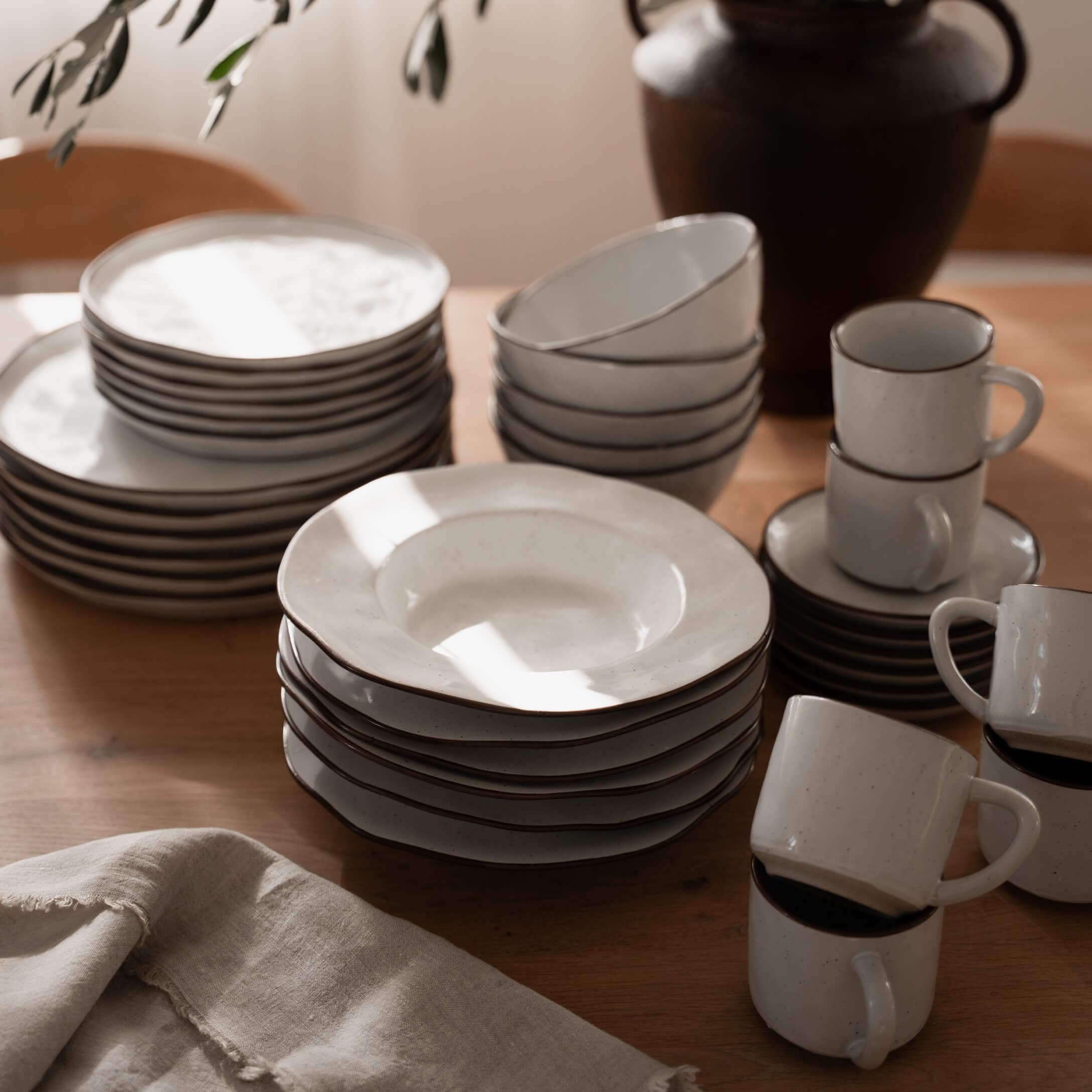 Wit keramisch servies met bruine rand op houten tafel, keukengerei