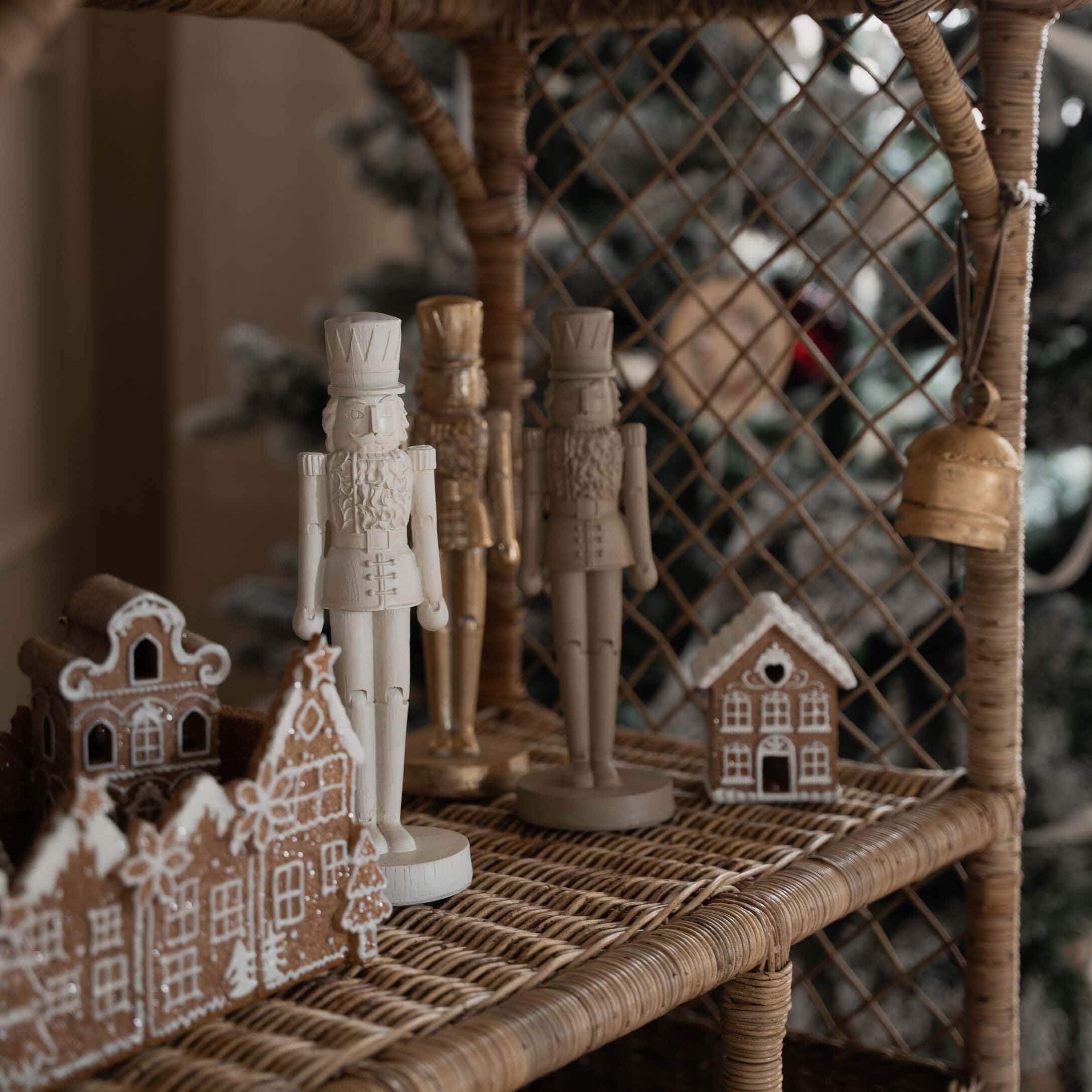 Houten notenkrakers in wit en beige op een rotan plank met peperkoekhuisjes