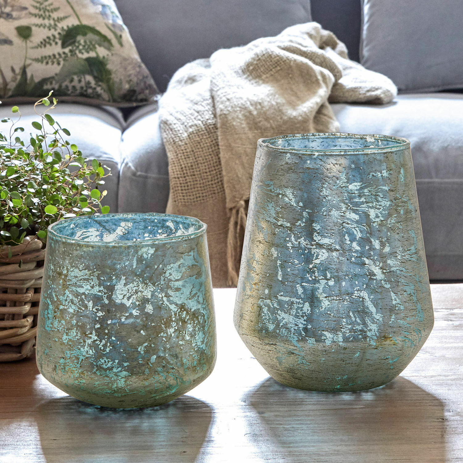 Windlicht set van 2 Gare Set van twee decoratieve blauwgroene glazen vazen op een houten tafel