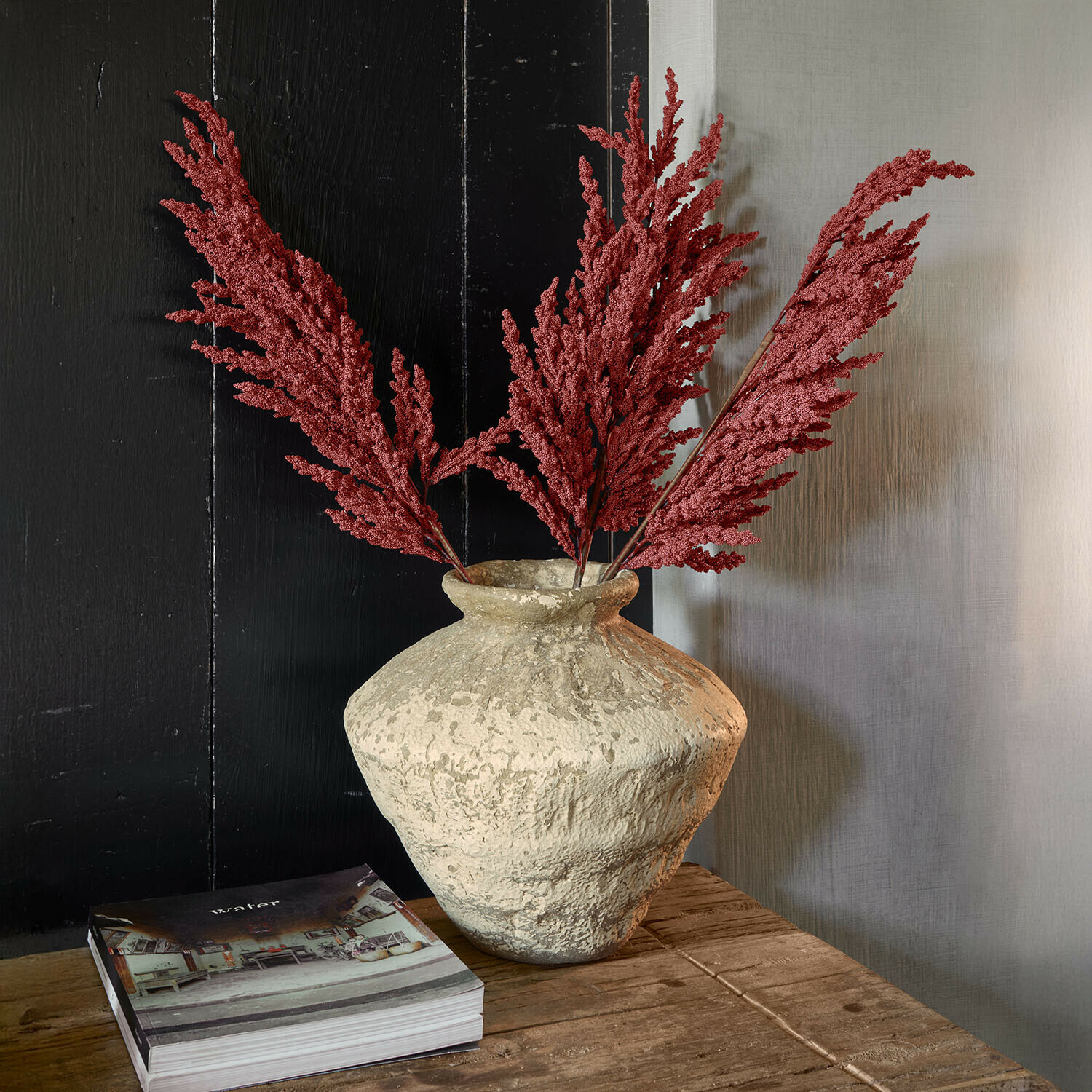 Vaas Moravinos Decoratieve aardewerken vaas met rode gedroogde takken op een rustieke houten tafel