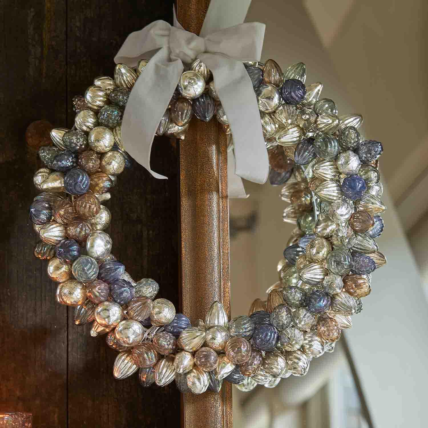 Decoratieve krans van gekleurde glazen bollen met witte strik, feestelijke woondecoratie