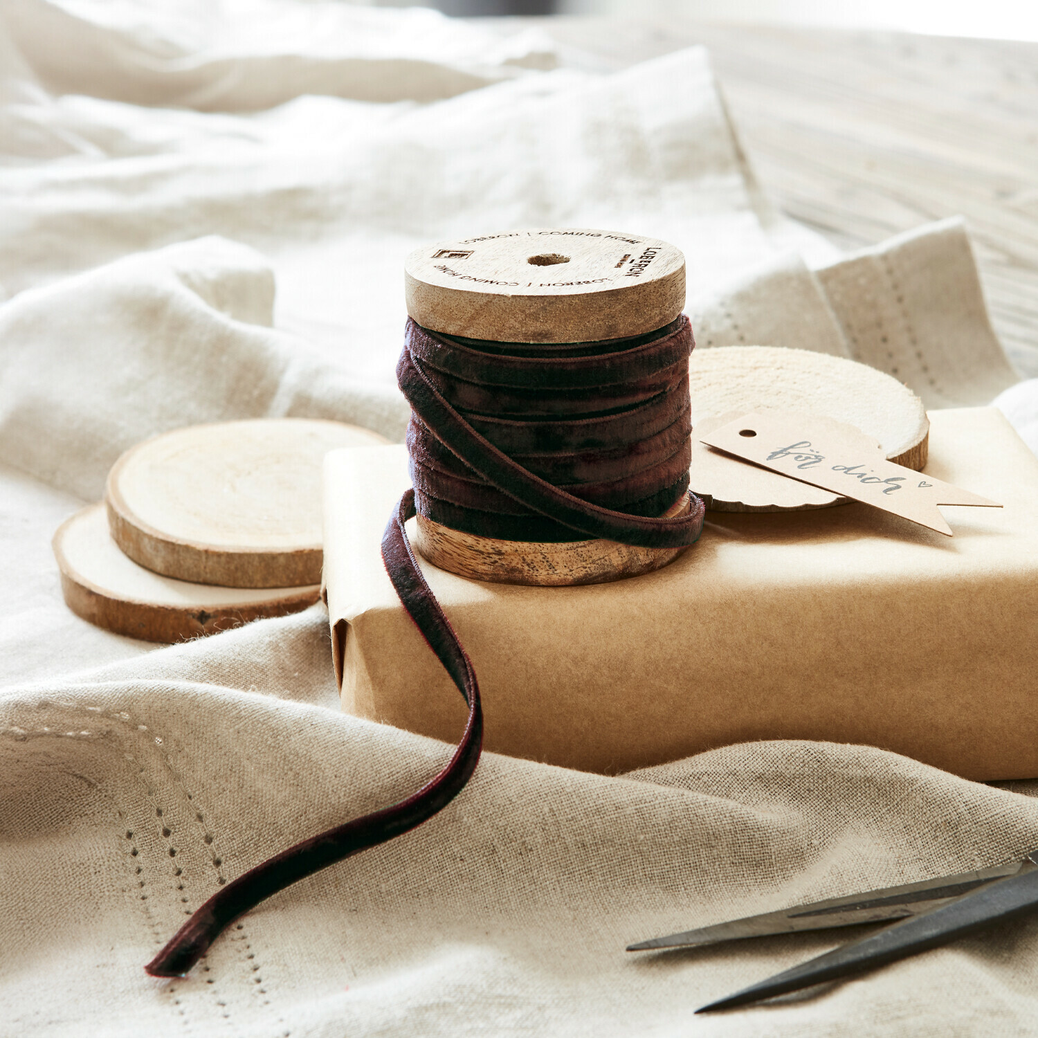 Bruine fluwelen lint op houten spoel met natuurlijke decoraties en schaar voor cadeauverpakking