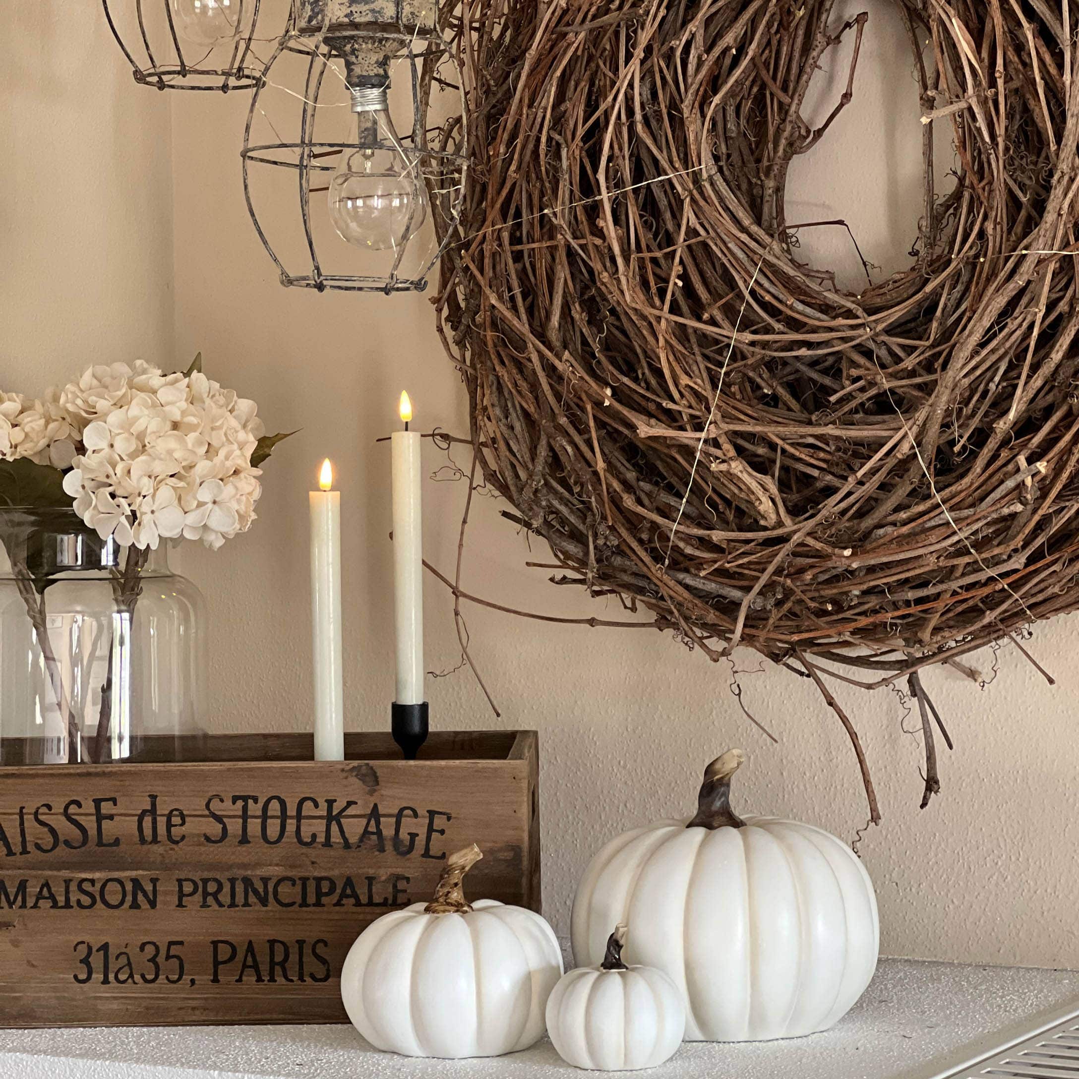 Herfstdecoratie met witte pompoenen, houten kist en natuurlijke takkenkrans voor binnen en tuin
