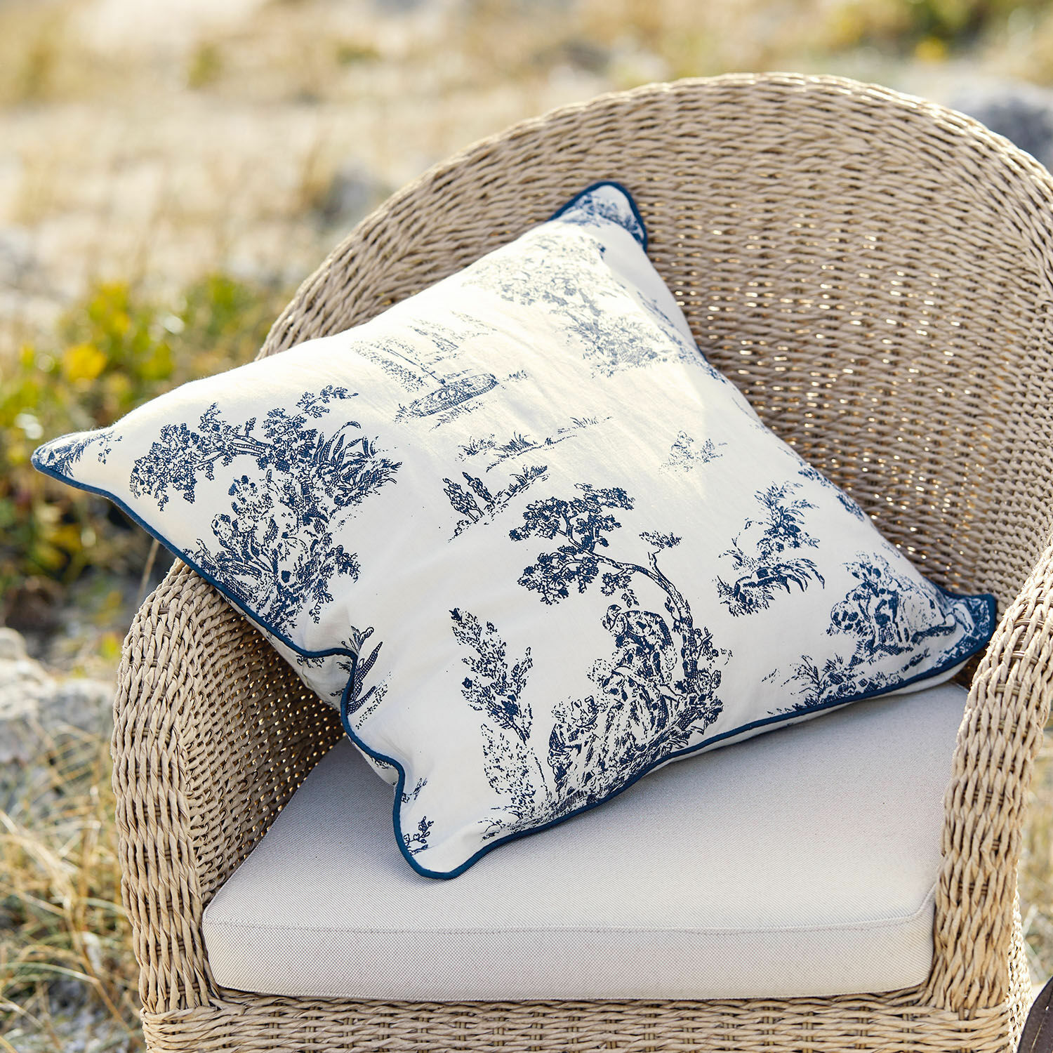 Kussenhoes Simone Decoratief katoenen kussen in wit met blauw klassiek patroon op rotan stoel