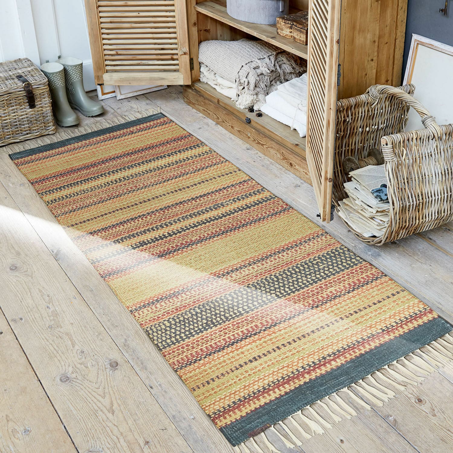 In- & outdoor loper Atlanta Gestreept vloerkleed in warme kleuren met franjes op houten vloer in rustieke stijl