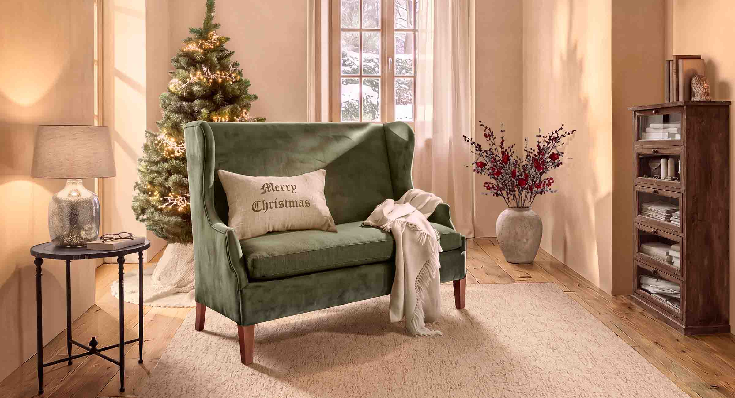 Groene fluwelen bank met Merry Christmas kussen in gezellige woonkamer met kerstboom