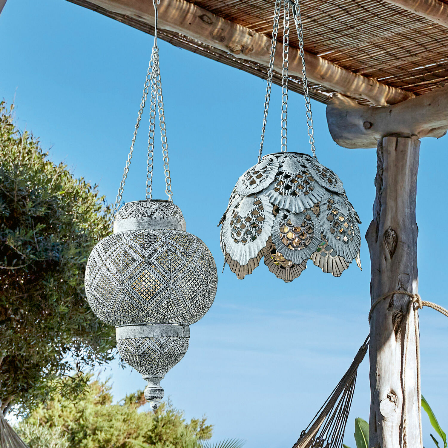 Twee hangende metalen lantaarns in wit met opengewerkt patroon, buiten tuin decoratie