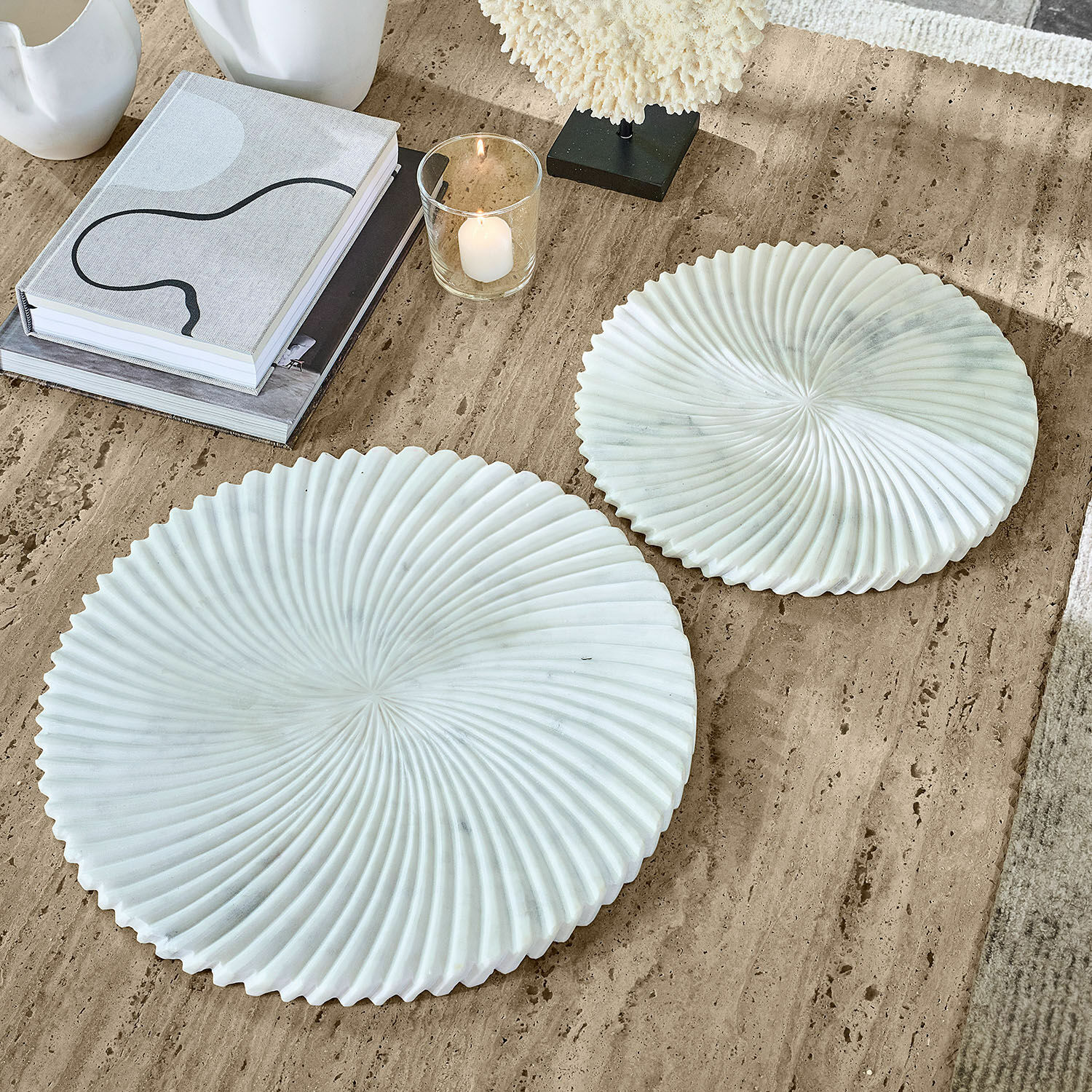 Twee witte marmeren decoratieve borden met golvend patroon op beige tafel, interieurdecoratie