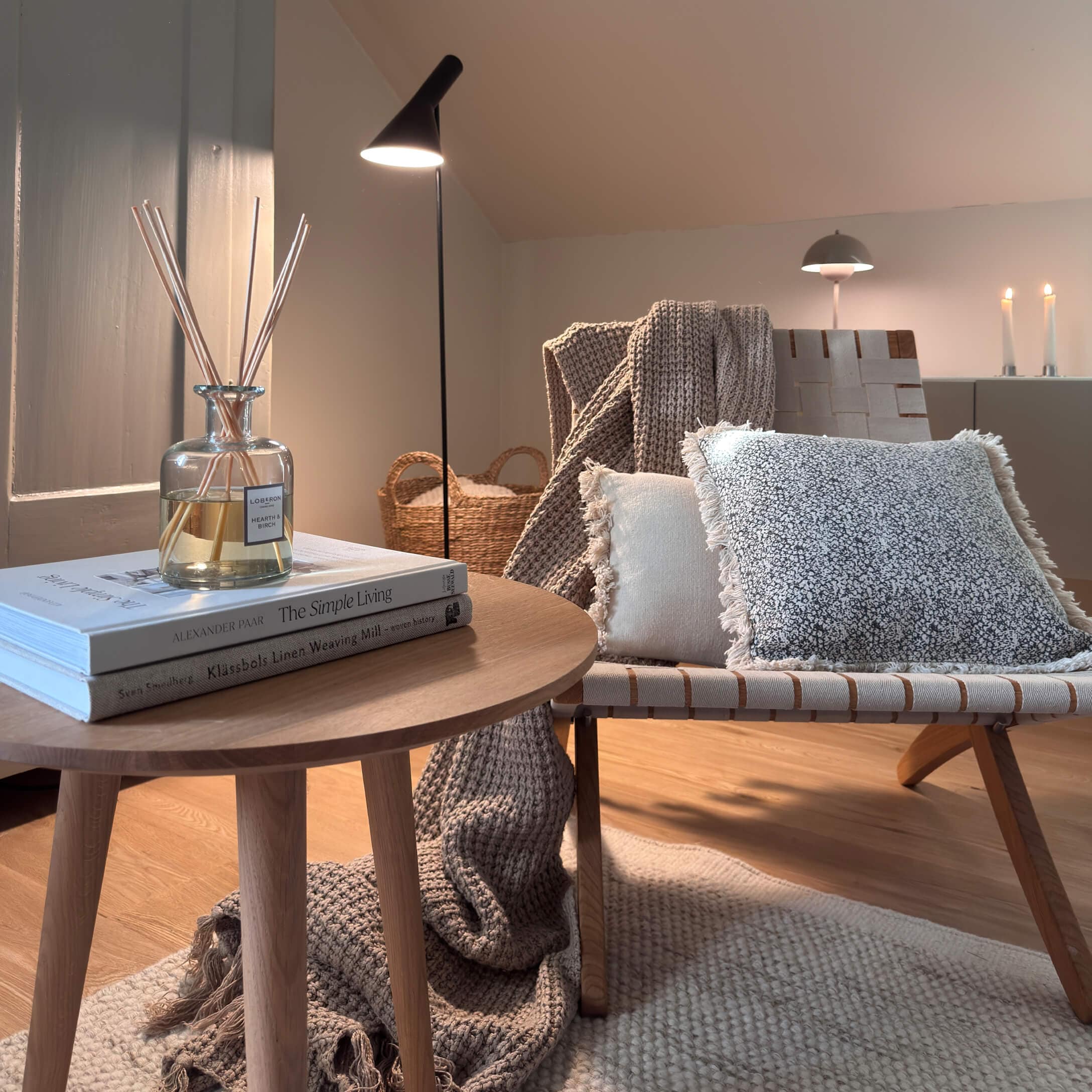 Gezellige hoek met houten tafel, lamp en zachte kussens in natuurlijke kleuren voor wooncomfort