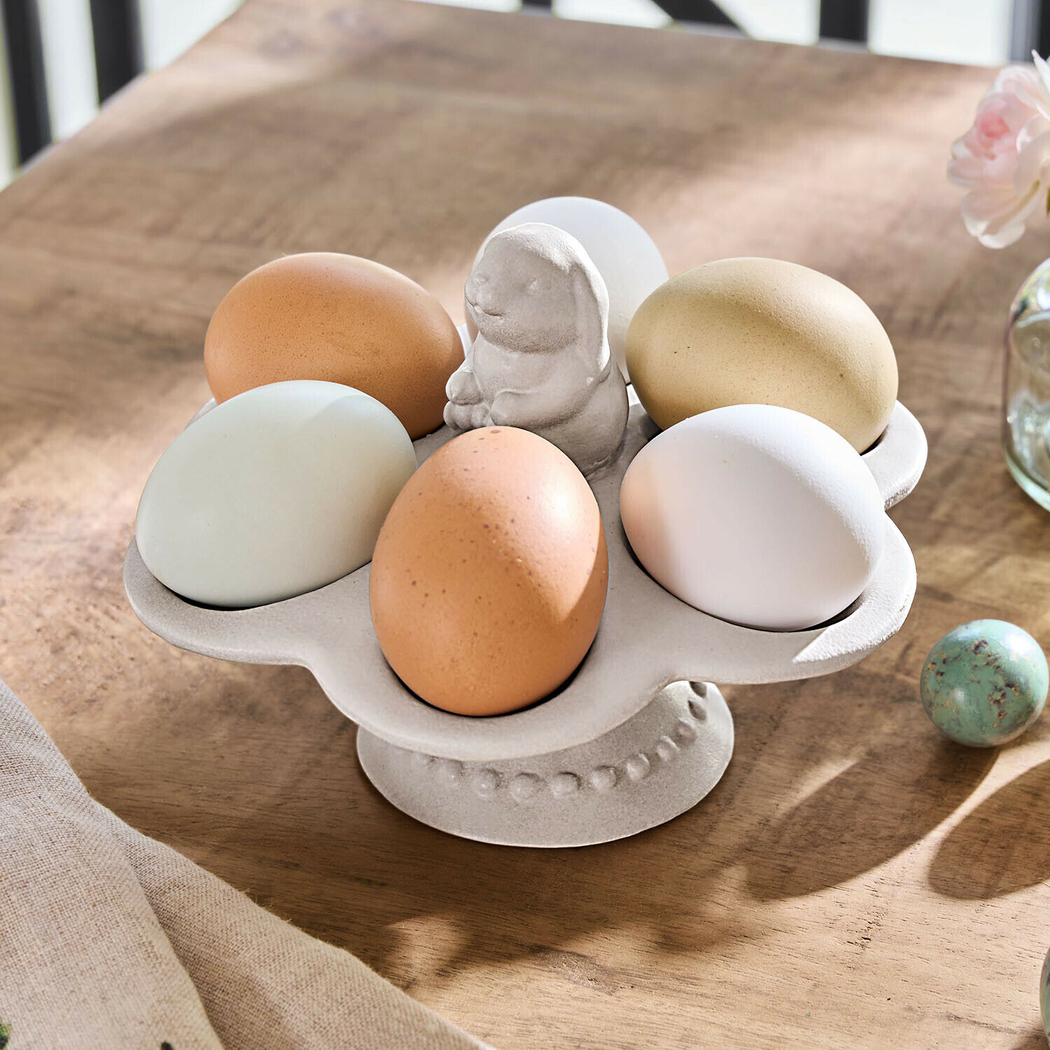 Beige keramische eierhouder met konijnenfiguur op houten tafel voor Pasen