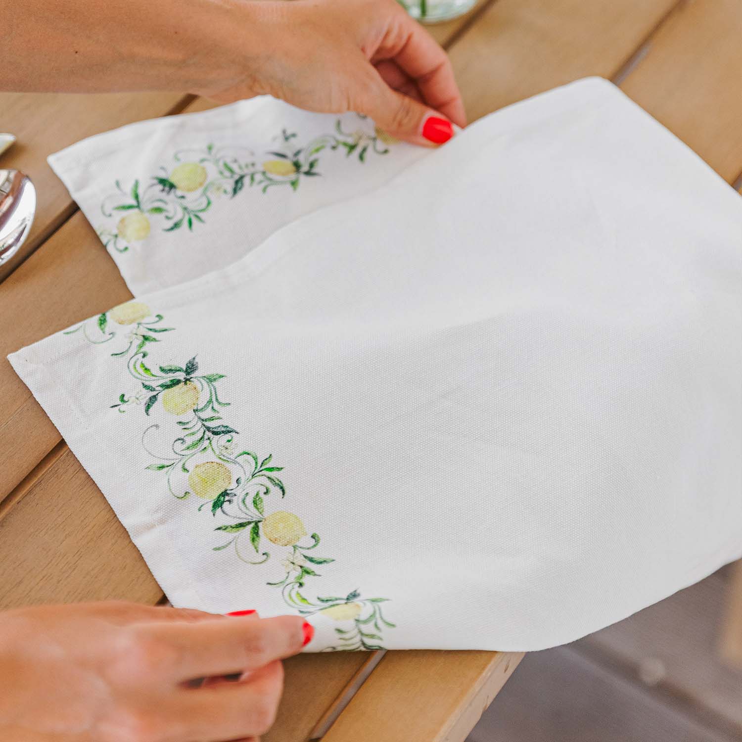 Witte linnen servet met groen-geel citroenpatroon op houten tafel, tafeldecoratie