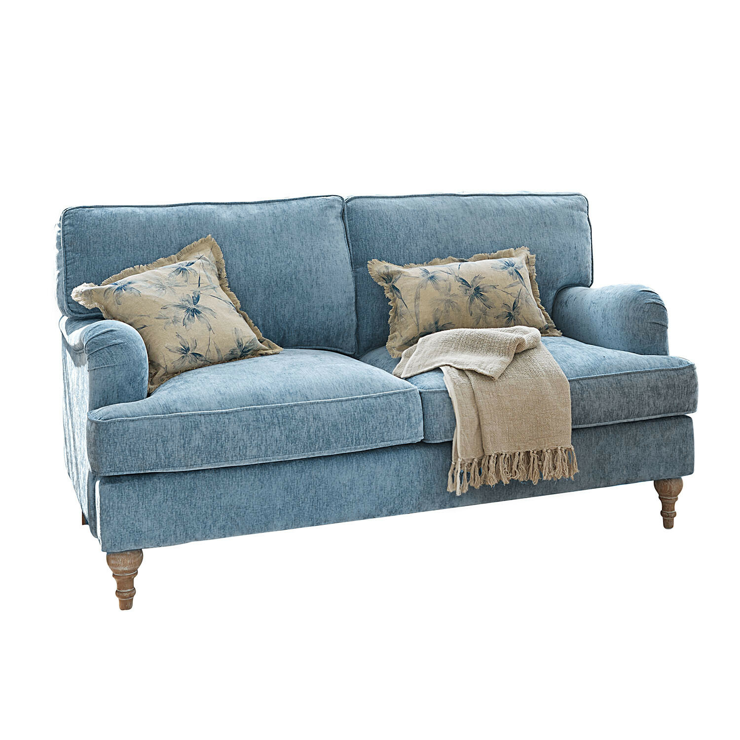 Blauwe stoffen bank met houten poten, versierd met een beige deken en kussens met plantenmotief